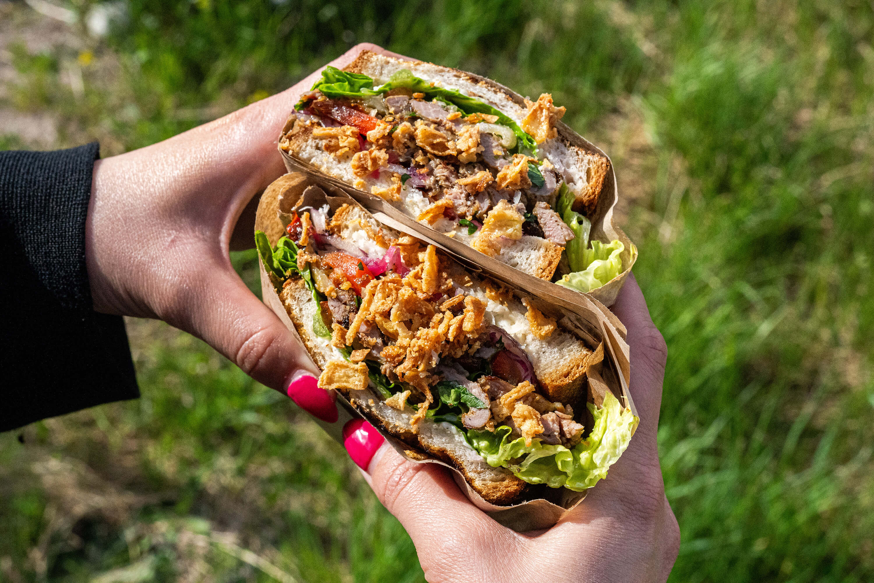 GBG Steak Cheese serverad med krispig sallad, stekt lök och saftigt kött från Oss bröd emellan