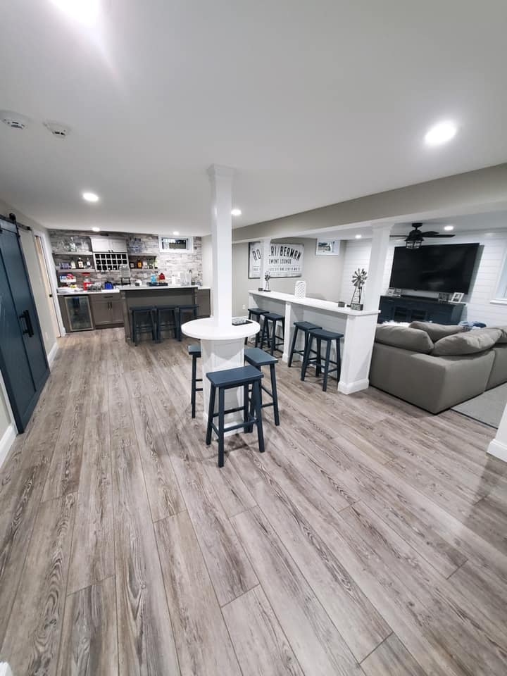 Finished basement renovation with custom bar, seating area, and luxury vinyl flooring