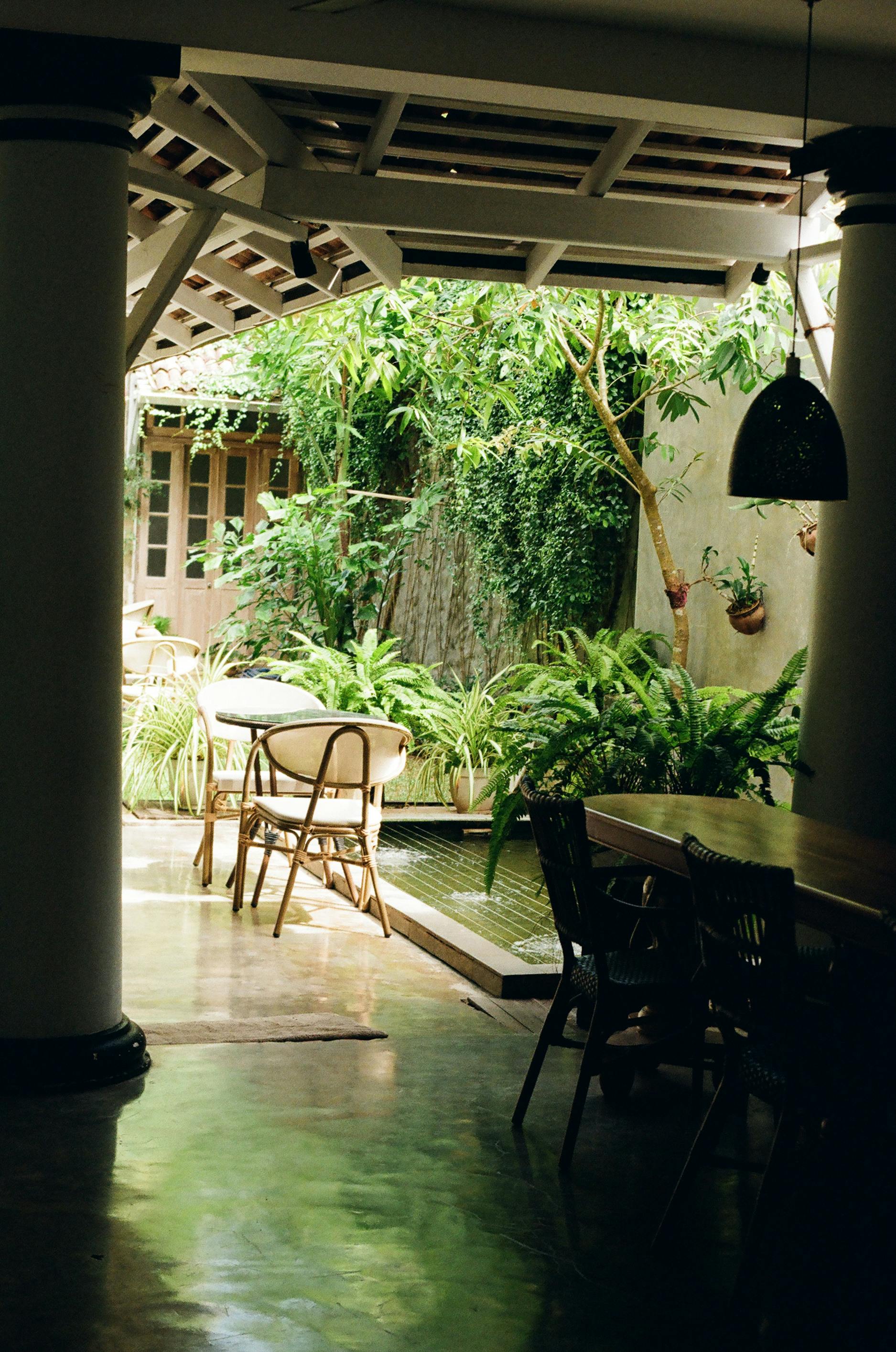 Woman in a light suit sitting thoughtfully against a terracotta wall