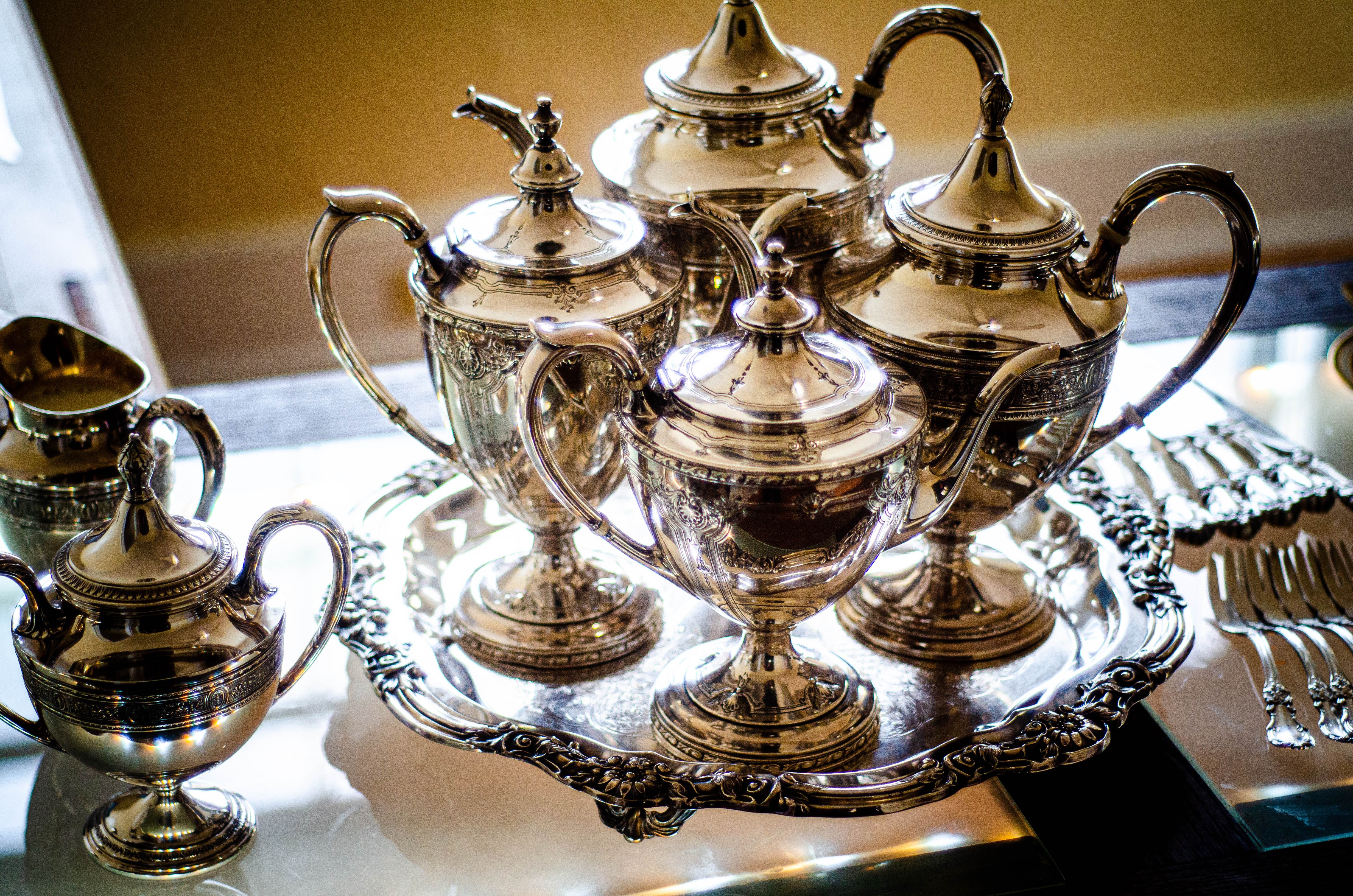 Fine sterling silver tea set and serving tray representing hollowware buyback services.