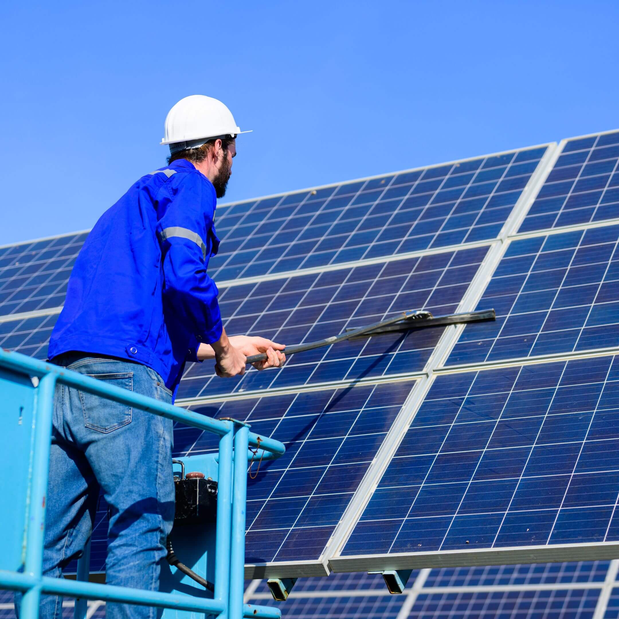 Technician cleaning rooftop solar panels to improve energy efficiency in Yorkshire