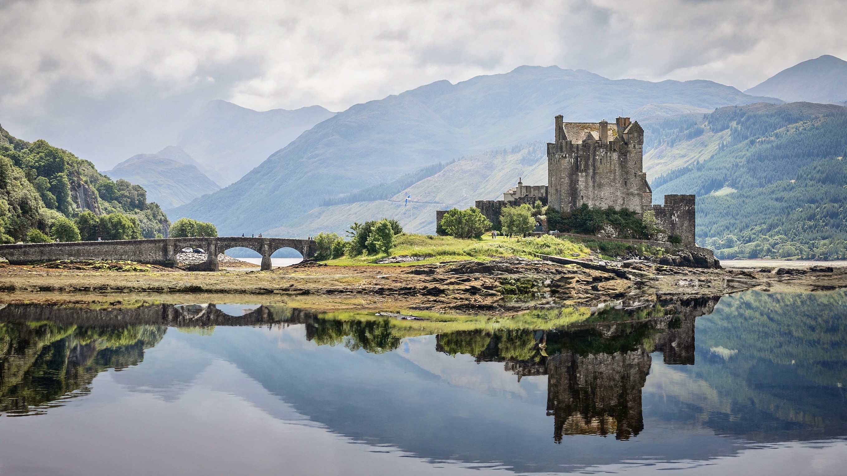 Elf woman in white dress raising hands by the river