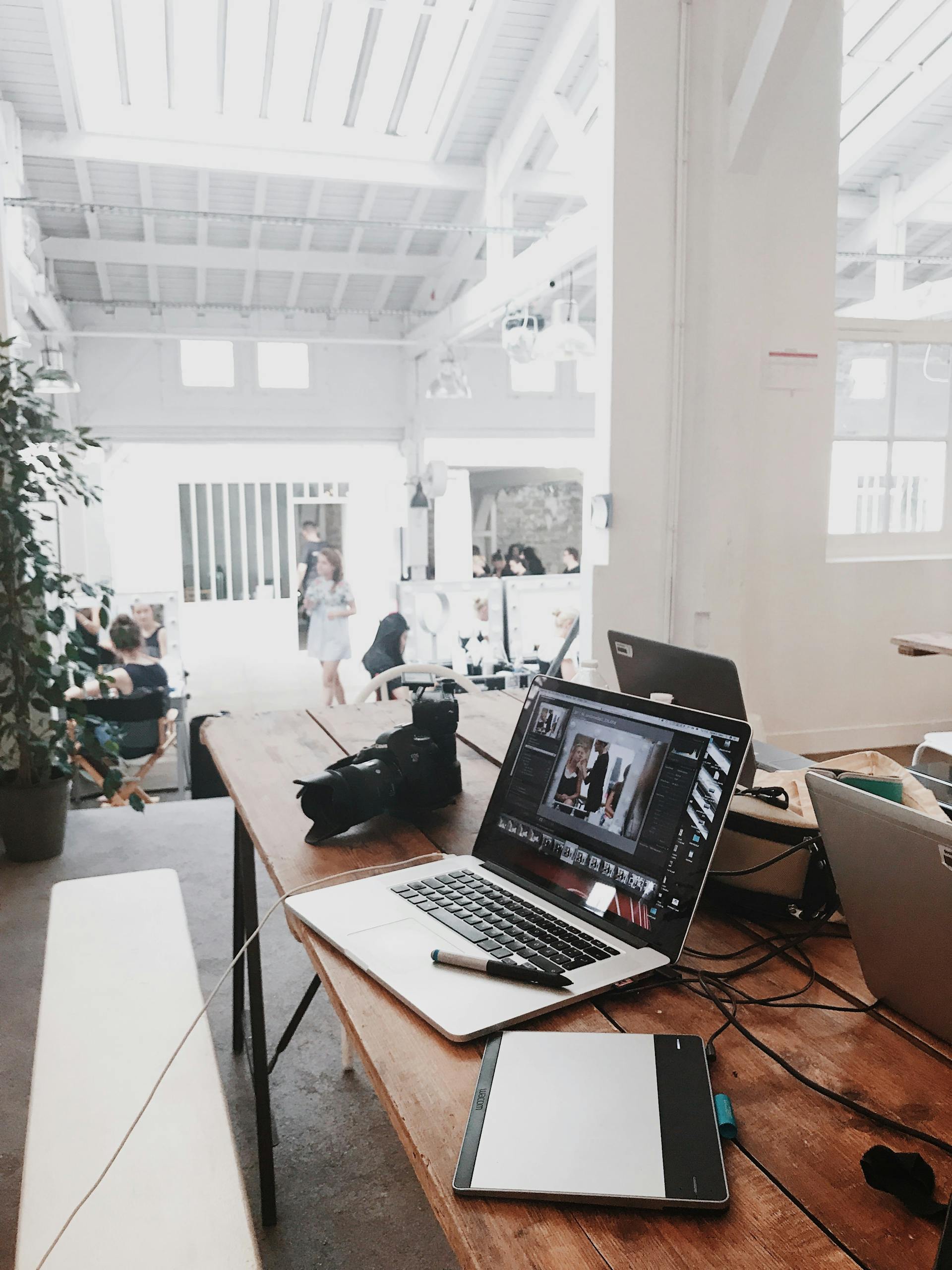 Kreativer Arbeitsplatz mit diversen Laptops und hellem Licht
