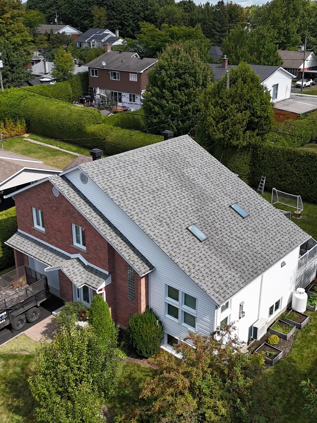 Toiture résidentielle en bardeaux d’asphalte installée sur une maison en rangée, vue aérienne après les travaux