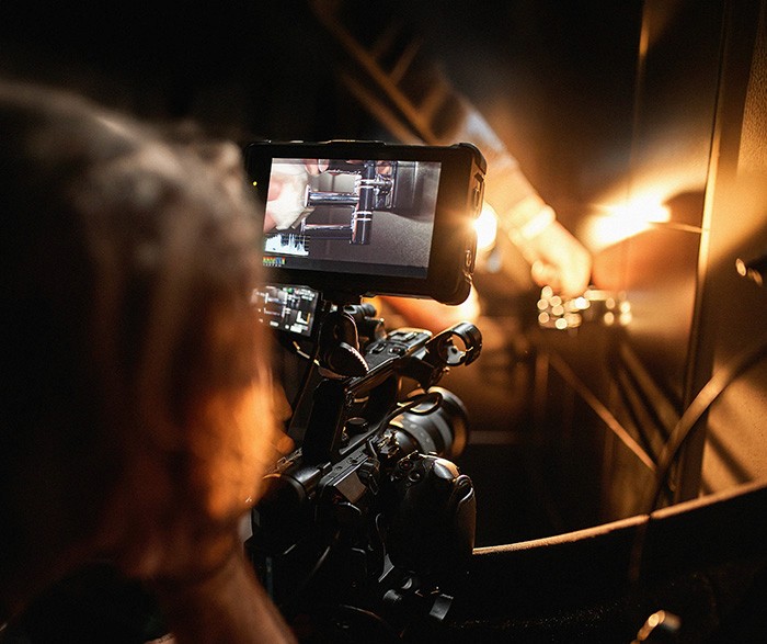 Person filming a scene with a professional camera, capturing a close-up shot under studio lighting.