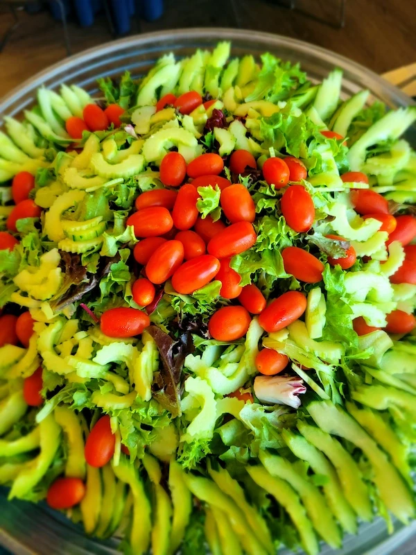 Large garden salad with fresh greens and cherry tomatoes for events