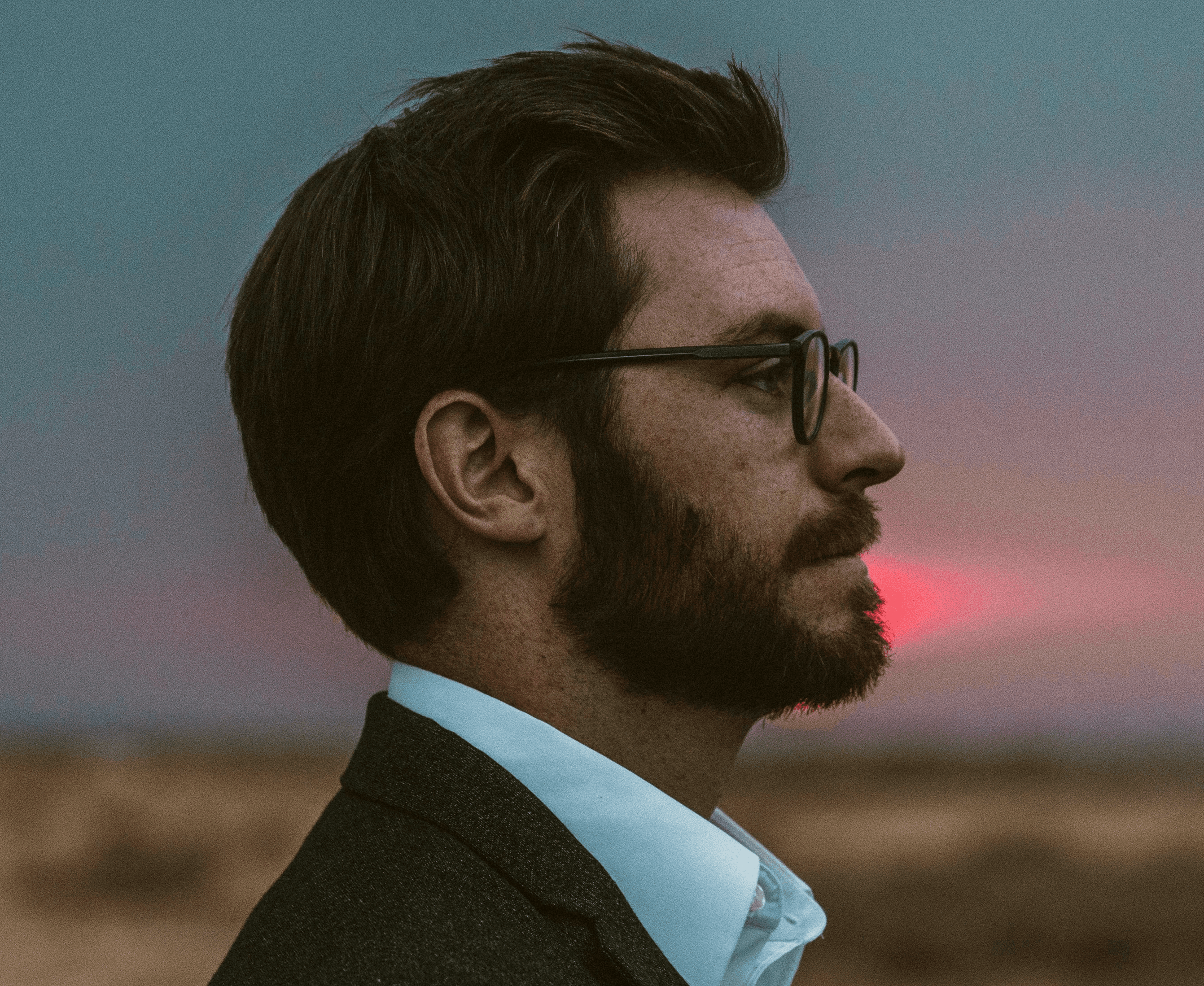man in black formal suit wearing eyeglasses