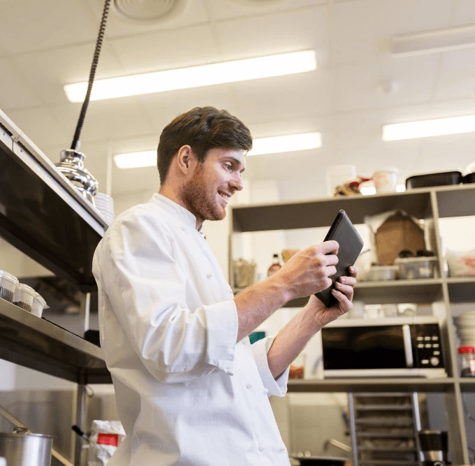 Chef in the kitchen using his tablet and HoustonPlus app.