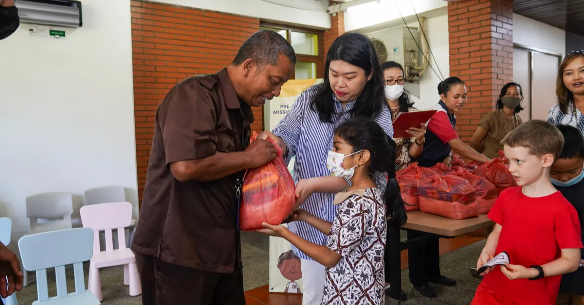 woman carrying white and green textbook