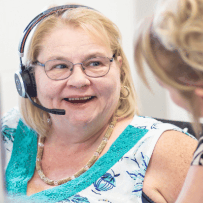 Women with a headset on her head, smiling.