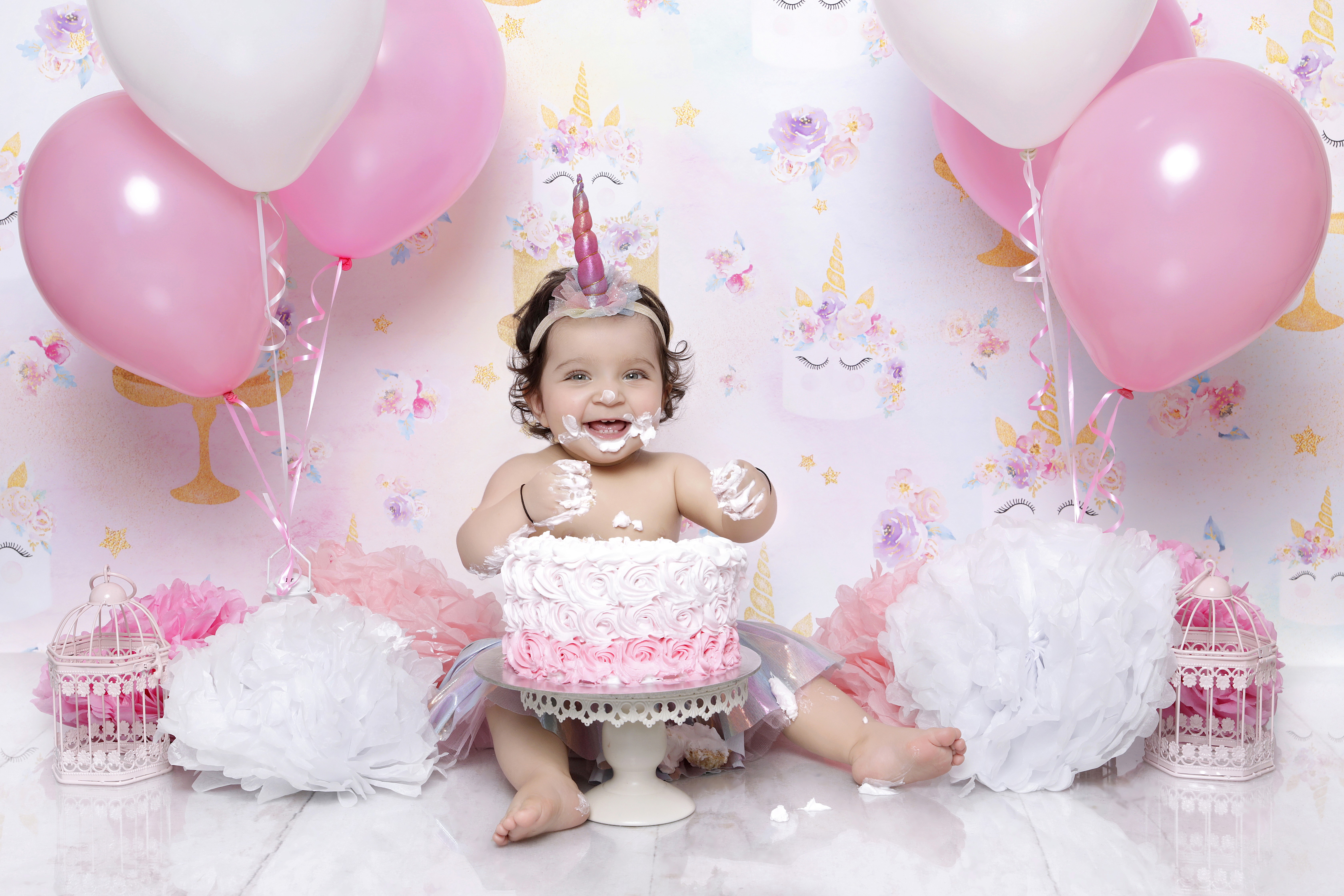 Baby celebrating her first birthday through a cake smash photography . 