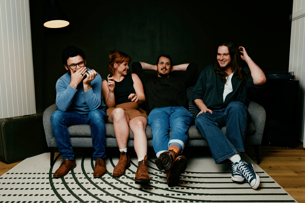 The Imperfect Creatives team laughing together on a sofa