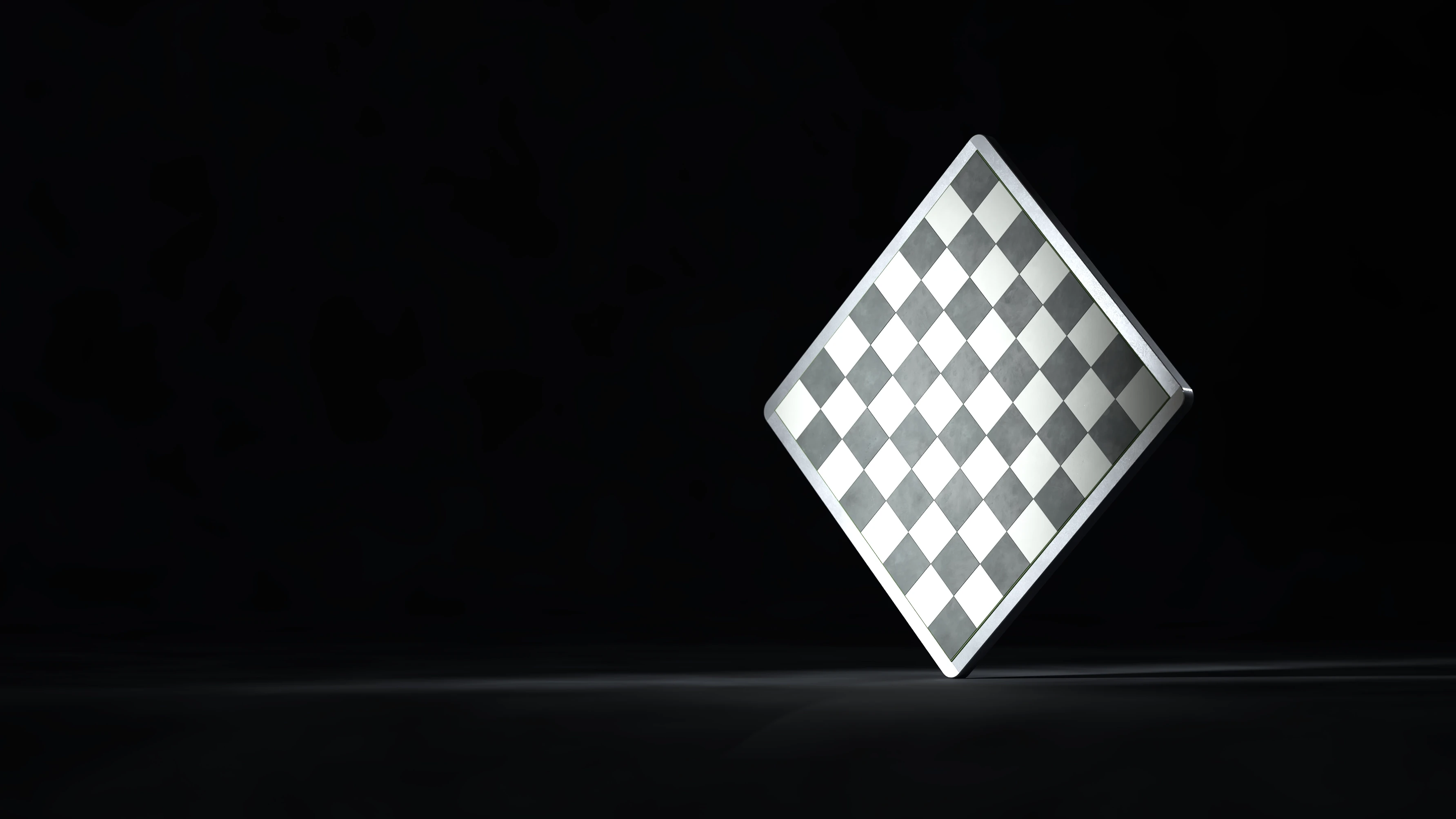 The Ferro aluminium-framed chessboard standing on edge in a single beam of light against a black background