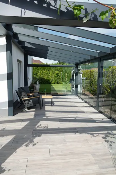 Terrassenverglasung mit Glasschiebeelementen und Glasdach als Sommergarten