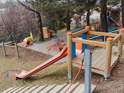 Venkovní hřiště s dřevěnou skluzavkou a průlezkami