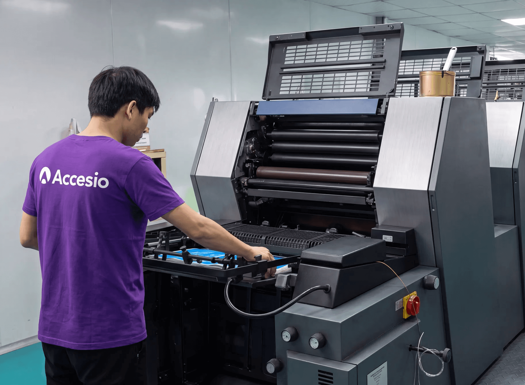 Accesio operator running the offset press where event credentials are printed