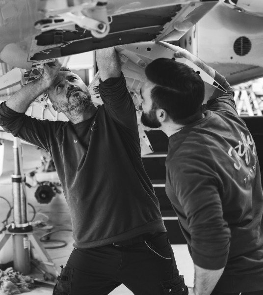 Two engineers fixing a Pilatus aircraft