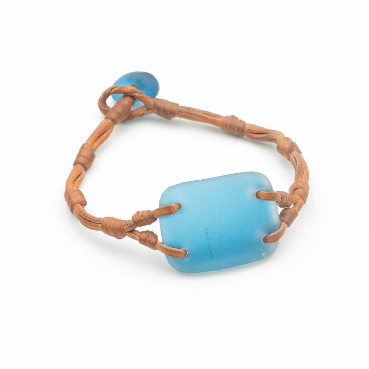 Frosted aqua Sea Glass bracelet on caramel leather cord with blue glass bead closure and hand-wrapped knots — Manos de Oro Saint Barth