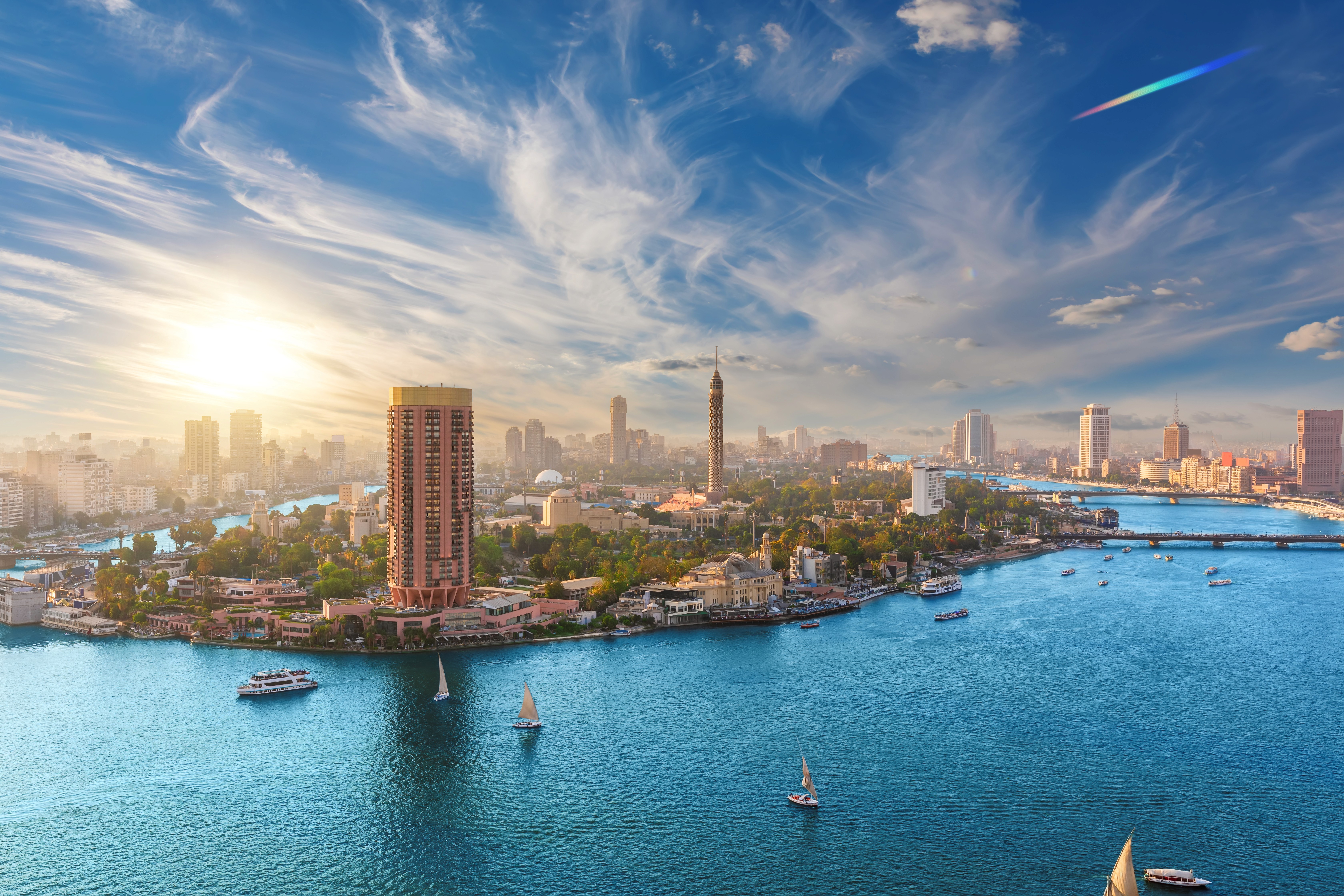 A boat traveling down a river next to a beach