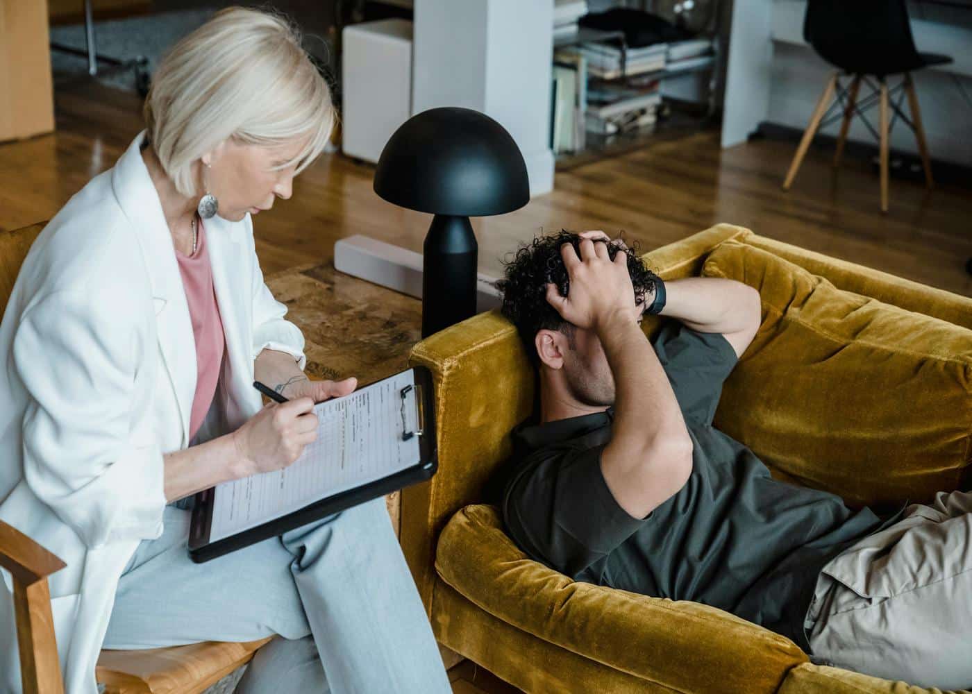 Woman performing a cognitive therapy test on a man lying on a couch