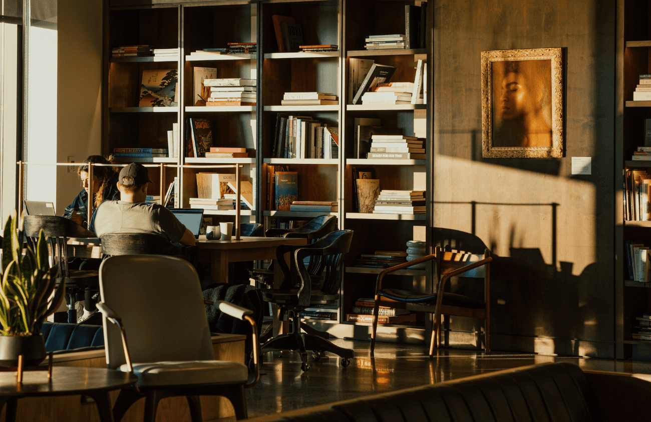 Four diverse professionals collaboratively working on a laptop, with one person pointing at the screen while others observe.