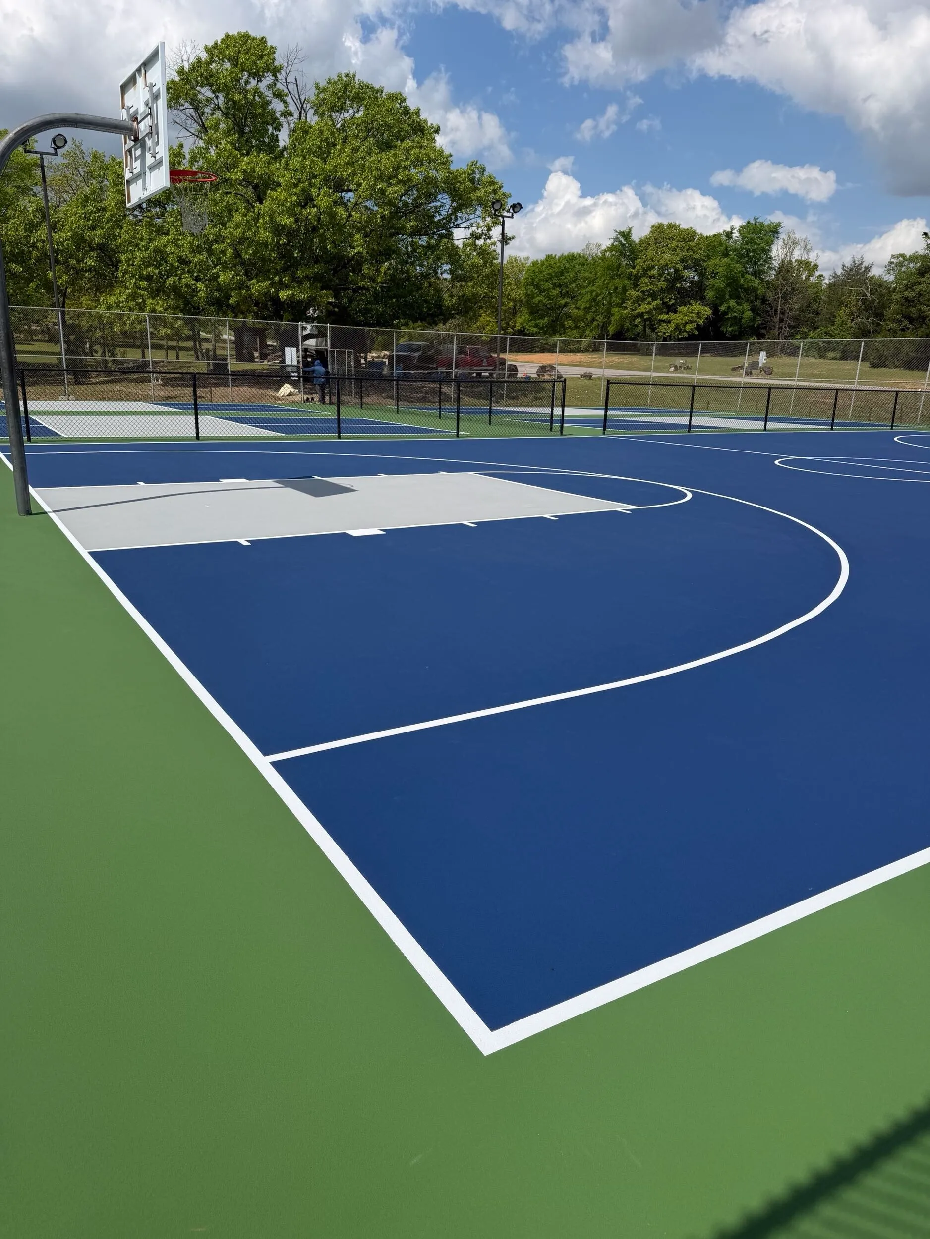Newly resurfaced basketball court showing the three-point arc and key at Bell Park in Greenwood, AR