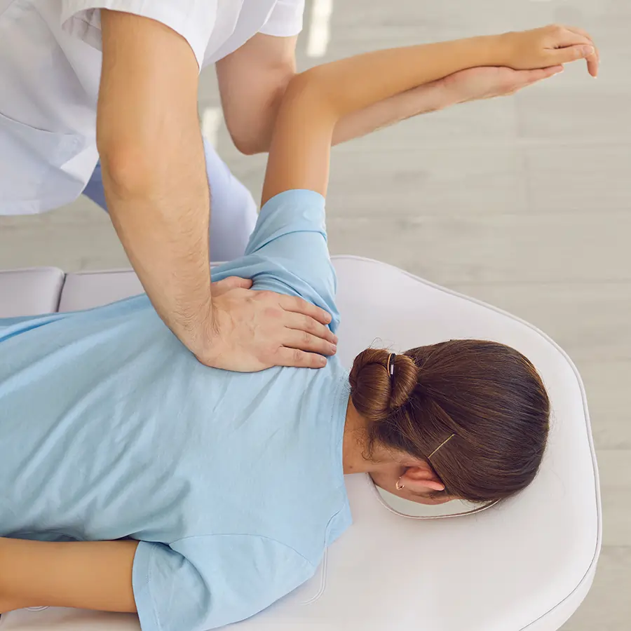 Woman receiving&nbsp;a chiropractic adjustment to her shoulder. 