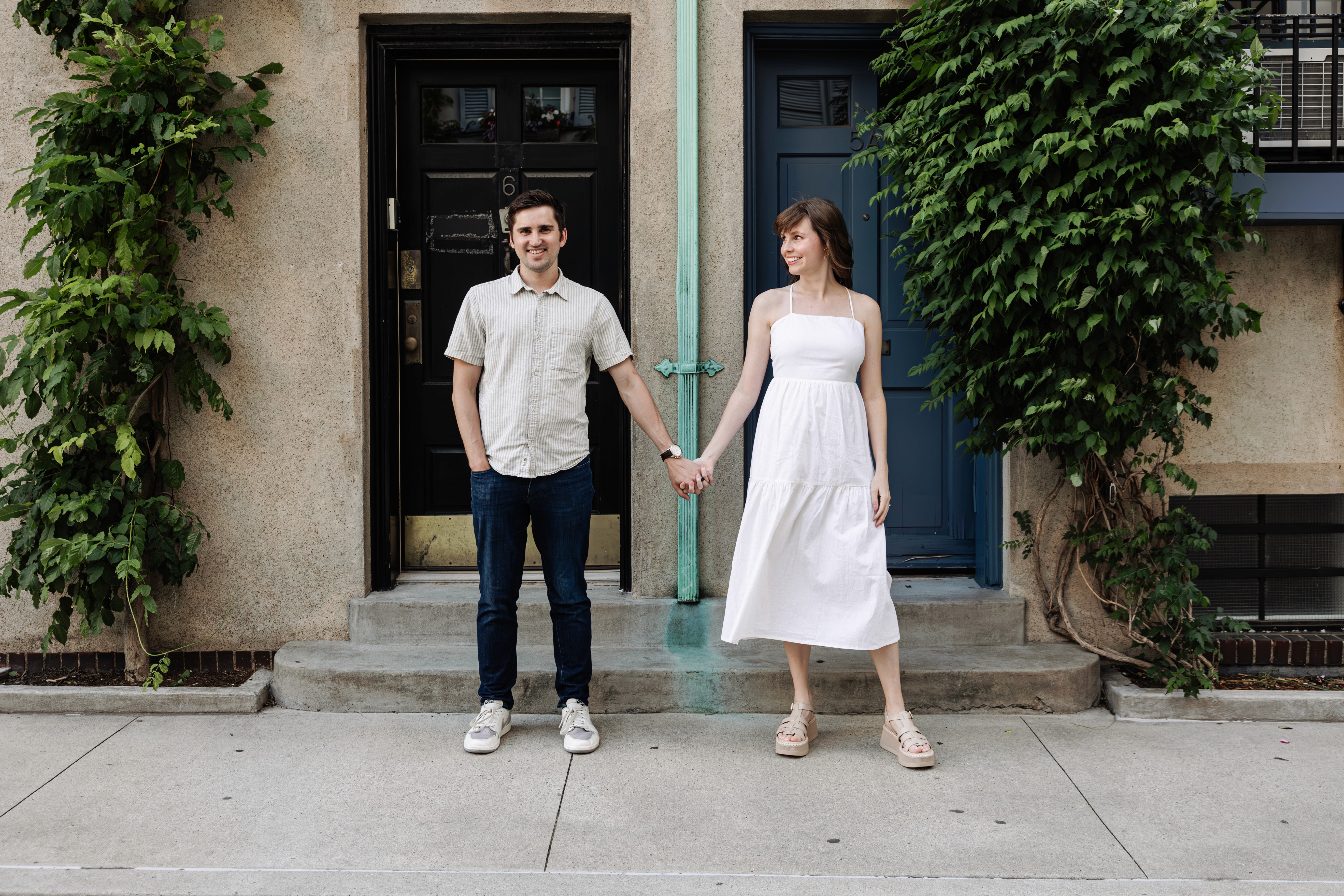 Newly engaged couple standing hand in hand on the charming cobblestoned Washington Mews in Greenwich Village, NYC — romantic engagement photography by Lizz Spano Photography, New York City engagement photographer.