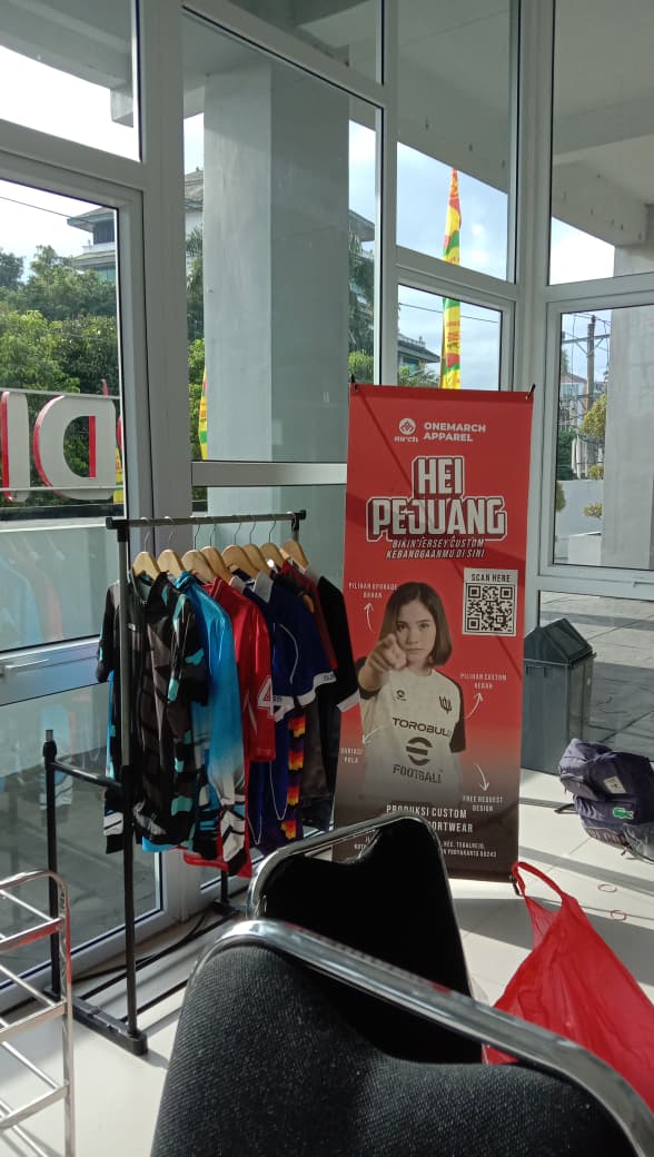 Dokumentasi partisipasi UMKM Jogja, One March Apparel, di gedung Pusat Desain Industri Nasional (PDIN). Menampilkan layanan produksi jersey custom dan digitalisasi bisnis apparel.