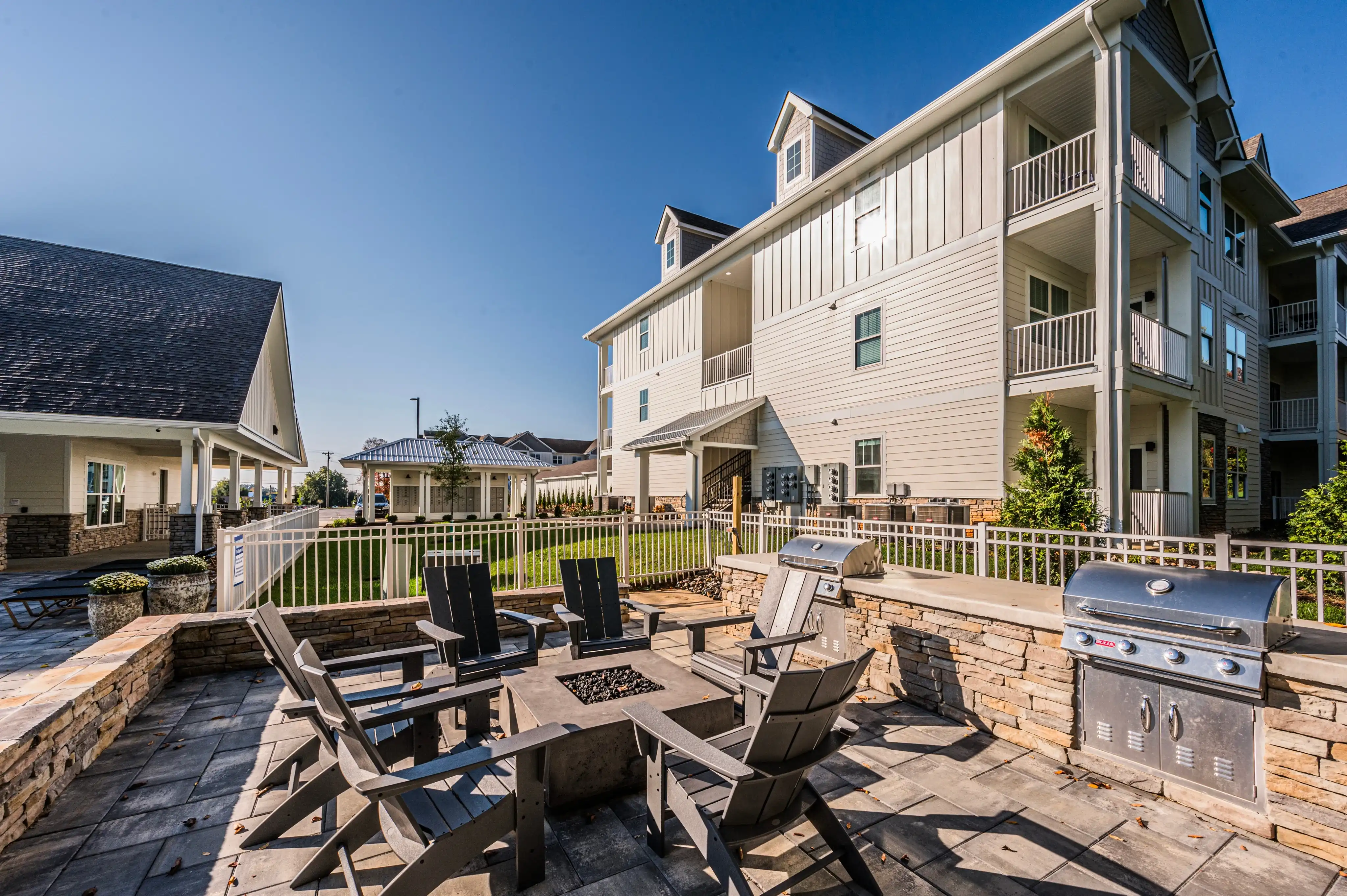 Outdoor BBQ grills and firepit gathering area at The Reserve at Cool Springs apartments