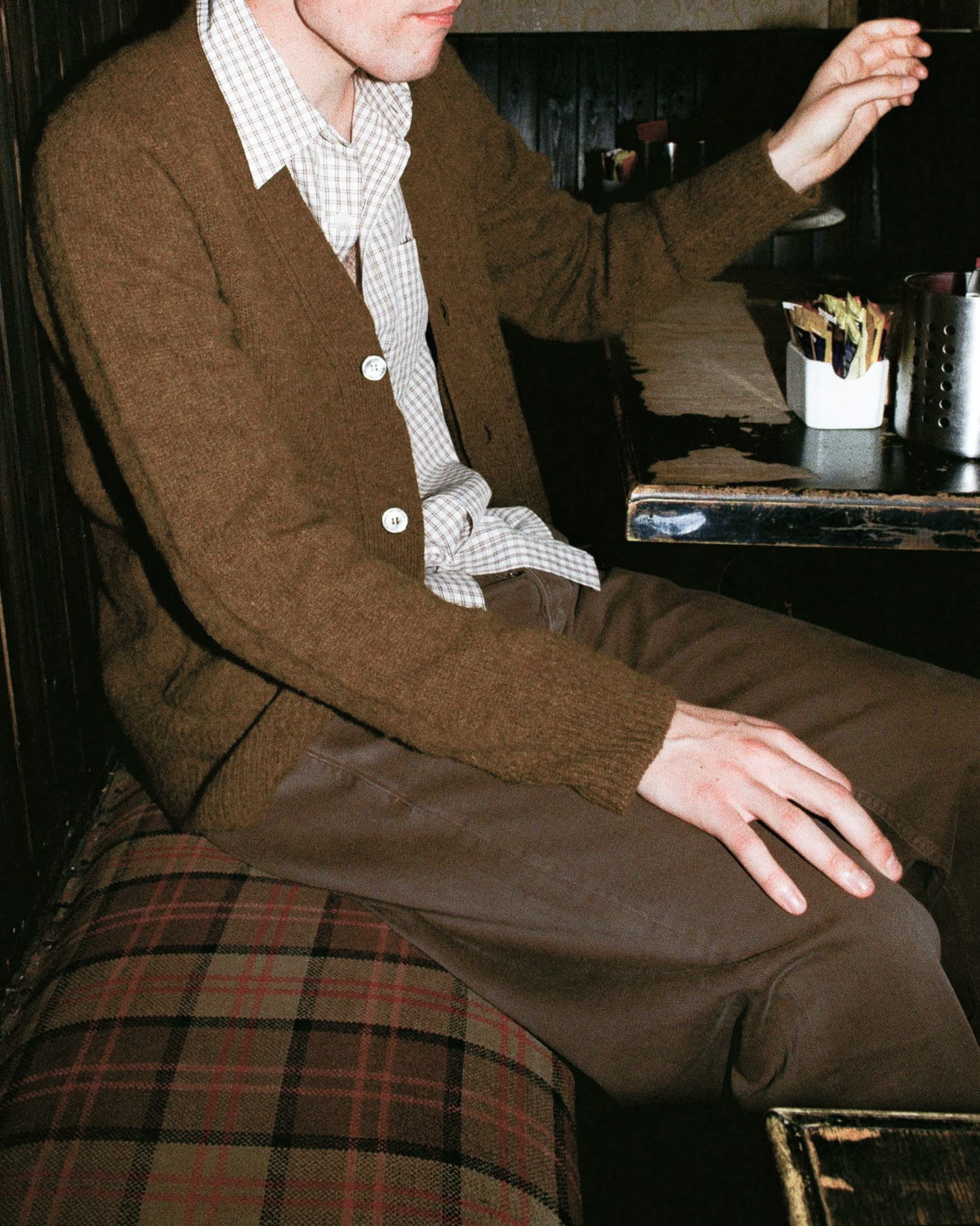 Au pub Ecossais, le mannequin porte un cardigan marron tricoté dans les highlands écossaises 