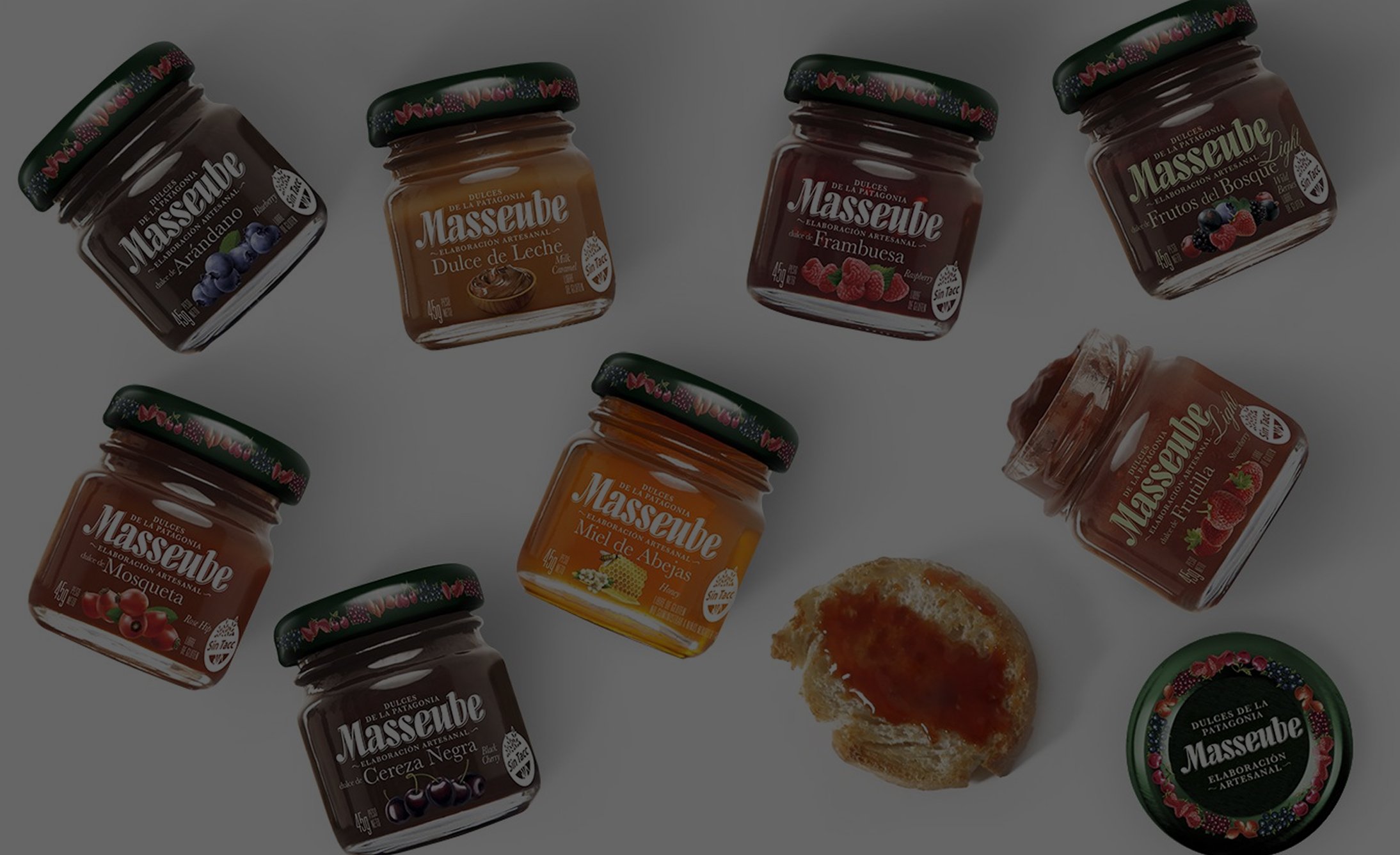 Un assortimento di sette barattoli di marmellata Masseube disposti in cerchio, ognuno con un diverso sapore di frutta. Una fetta di pane con marmellata è nelle vicinanze. Il tono è invitante e colorato.