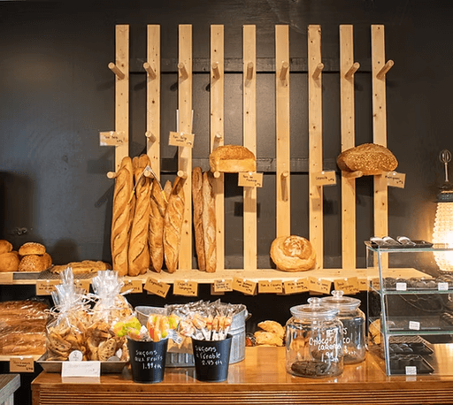 Comptoir de la pâtisserie Dorville garni de baguettes, pains et viennoiseries dans un décor chaleureux en bois.
