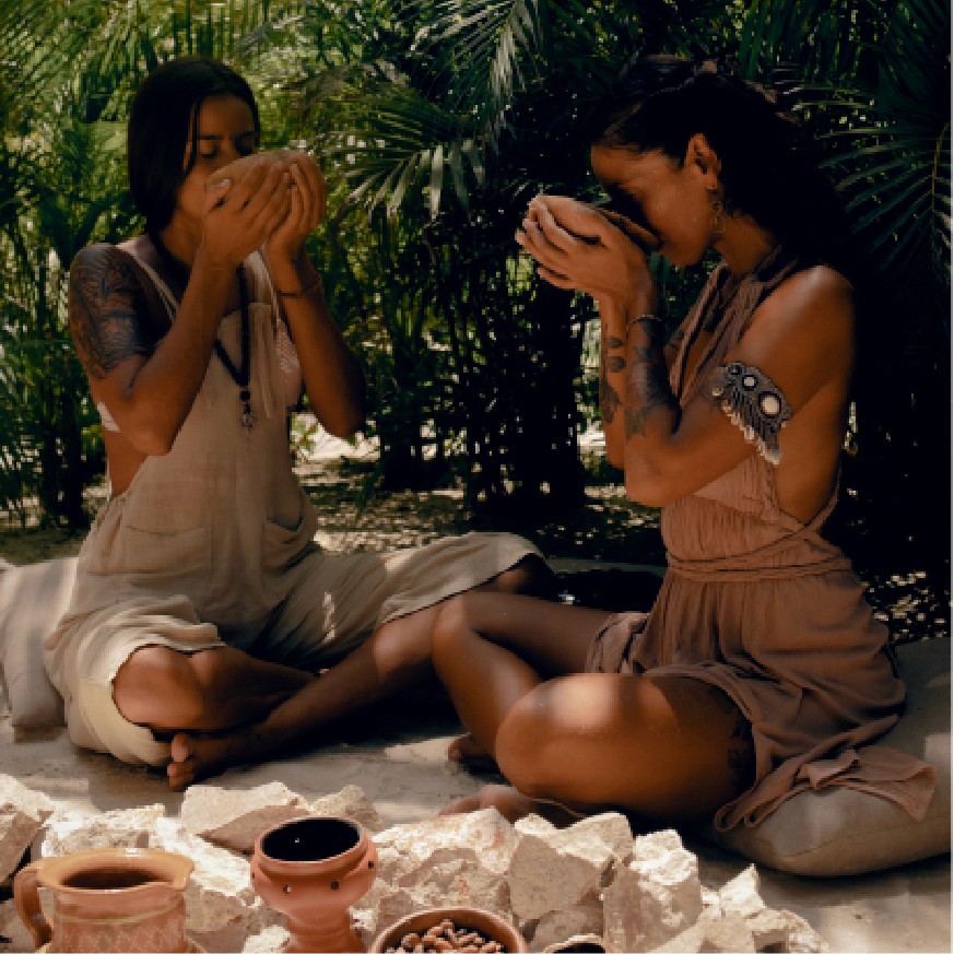 Group of people discussing their spiritual yoga journey on the beach at Nomade Holbox in Holbox Mexico, with a serene and peaceful atmosphere