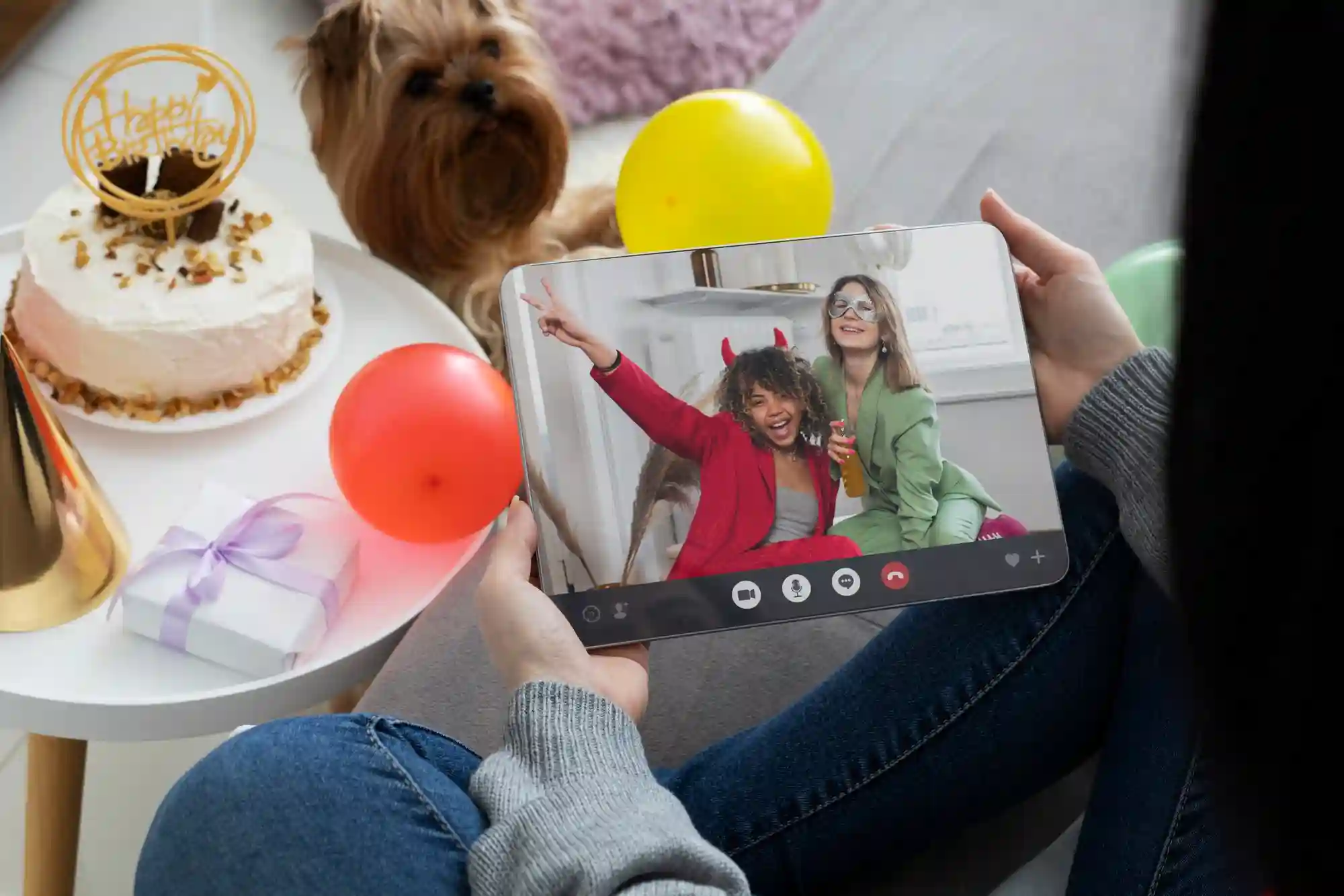 Virtual celebration showing a person on a video call while surrounded by birthday cake and party gifts.