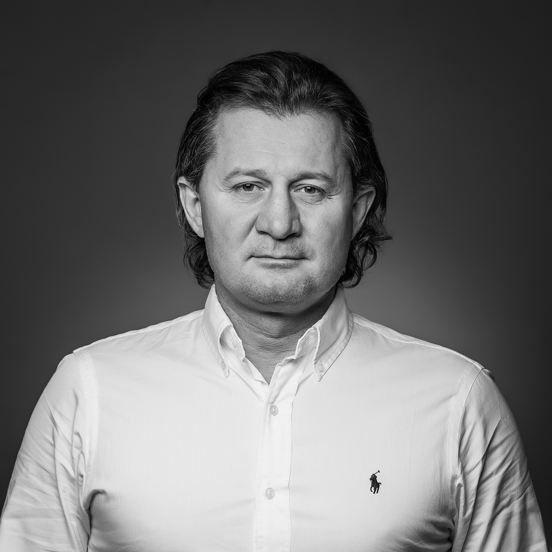 Middle-aged man with long hair in a white shirt