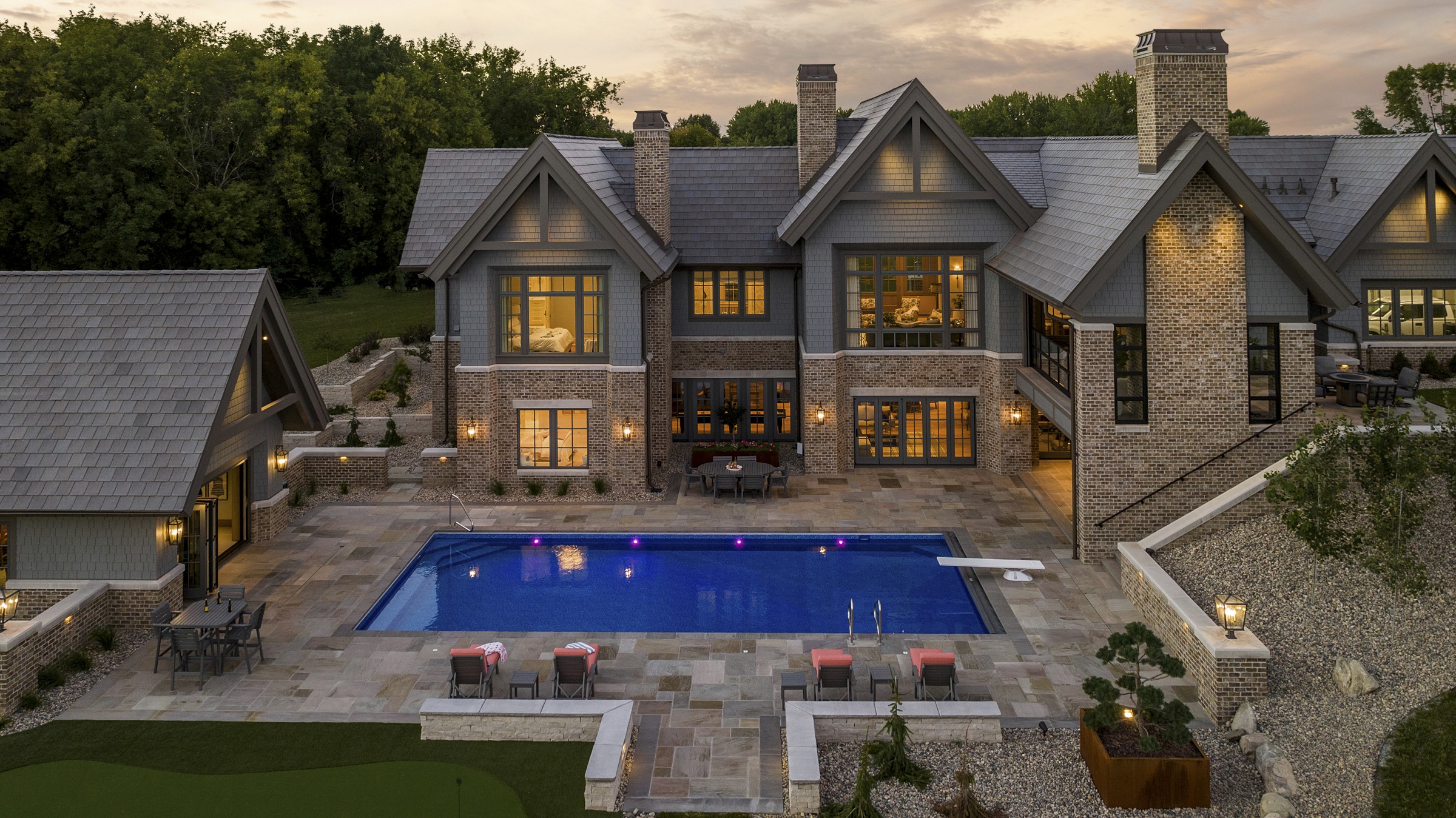 Pearson Lake Pool House Charleston - Aerial view of pool house exterior with illuminated pool and landscaping by Renae Keller Interior Design