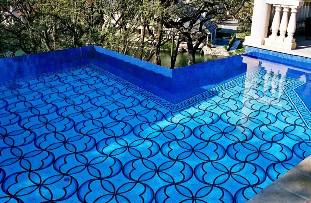 Vivid geometric mosaic glass pool with intricate blue patterns, perfect for outdoor luxury and artis.
