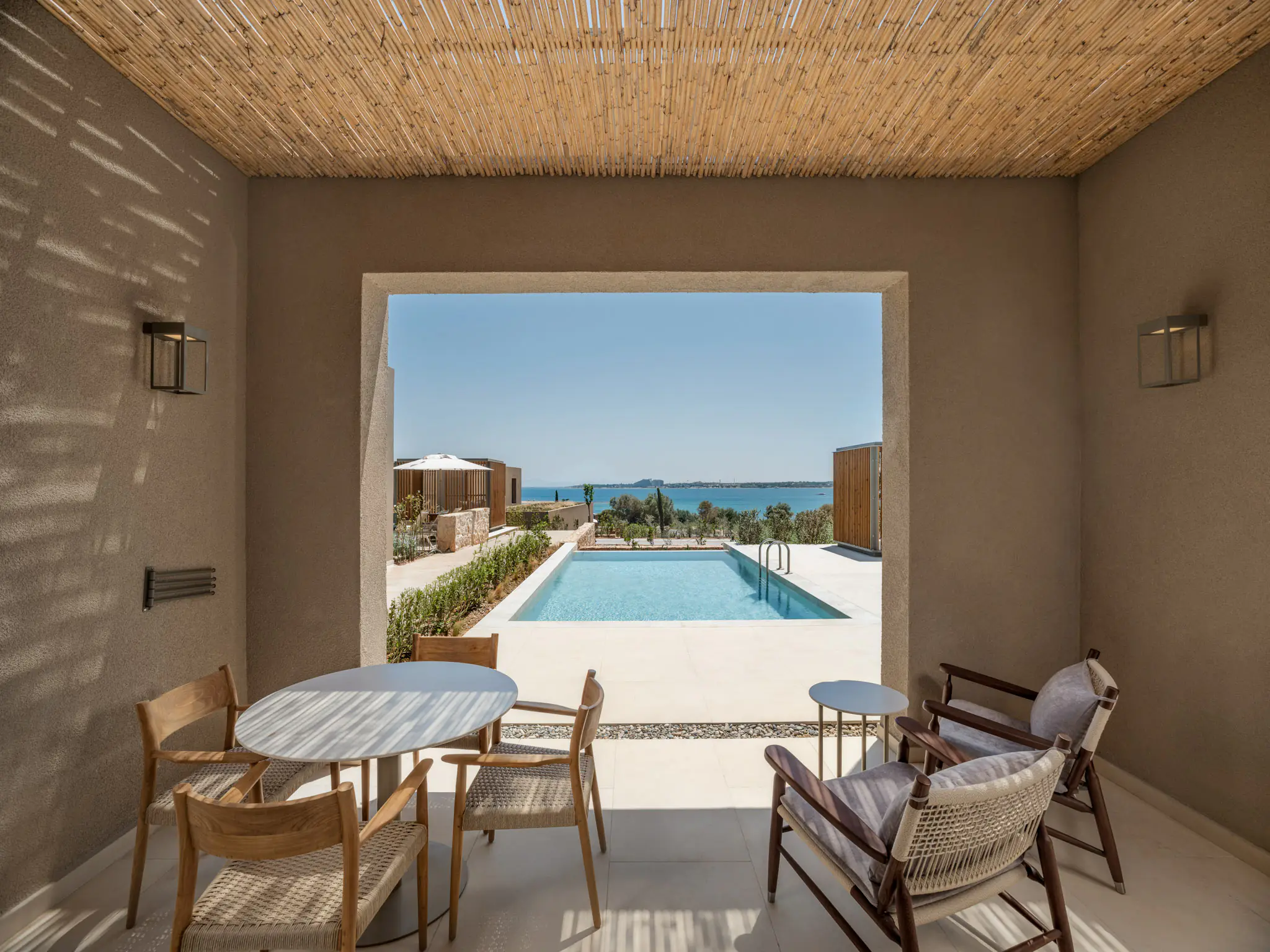 View from the reed-ceilinged veranda to the private pool and the sea
