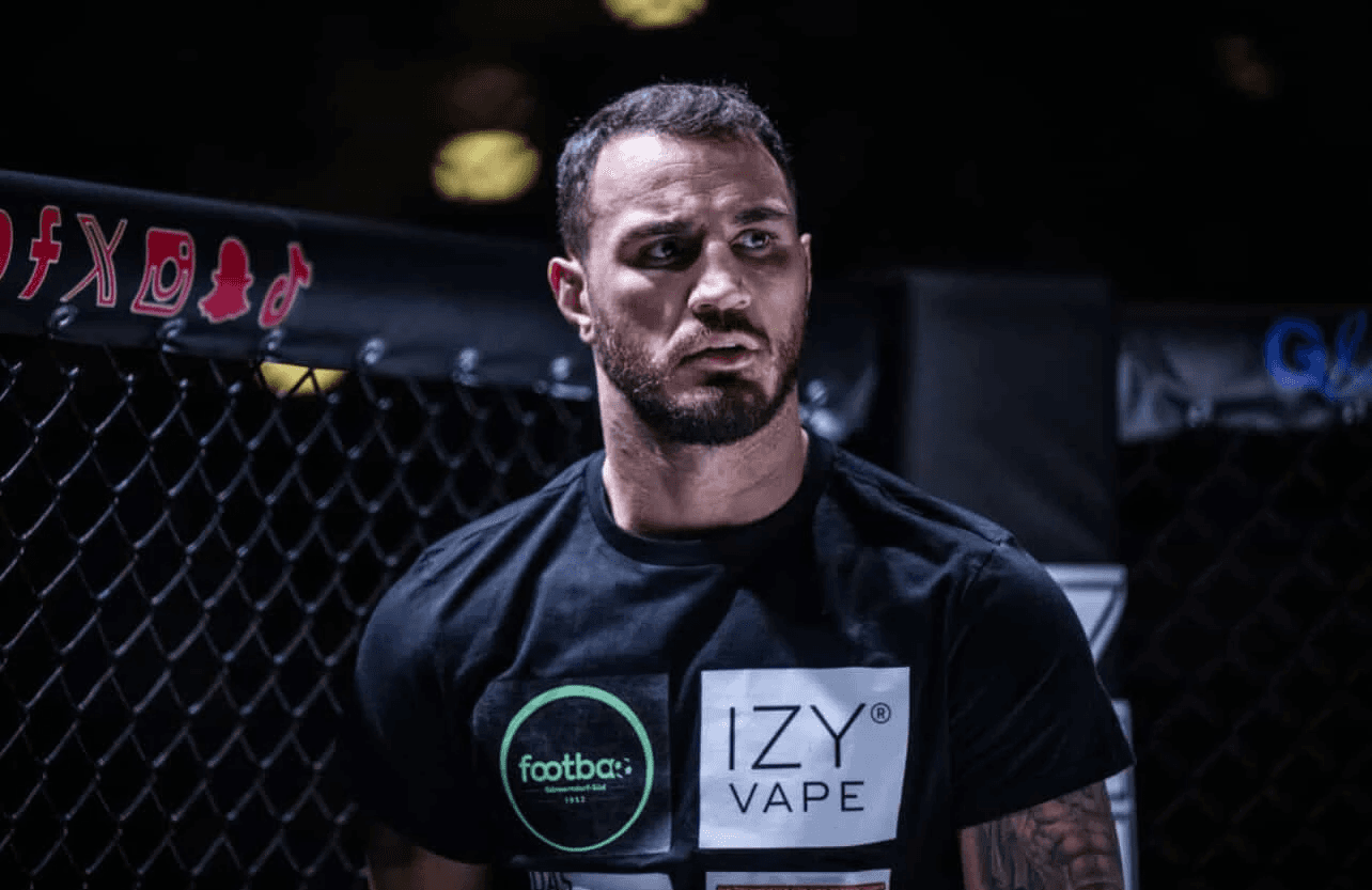 Portrait of Agron Smaski professional boxing and MMA coach in a gym, promoting private and online coaching.