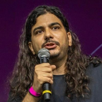 Lucas Ferreira, Vinteum co-founder, speaking at a Bitcoin conference holding a microphone