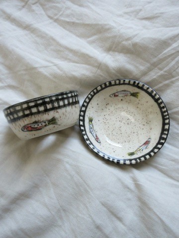 Small speckled white ceramic dish with black checkered rim