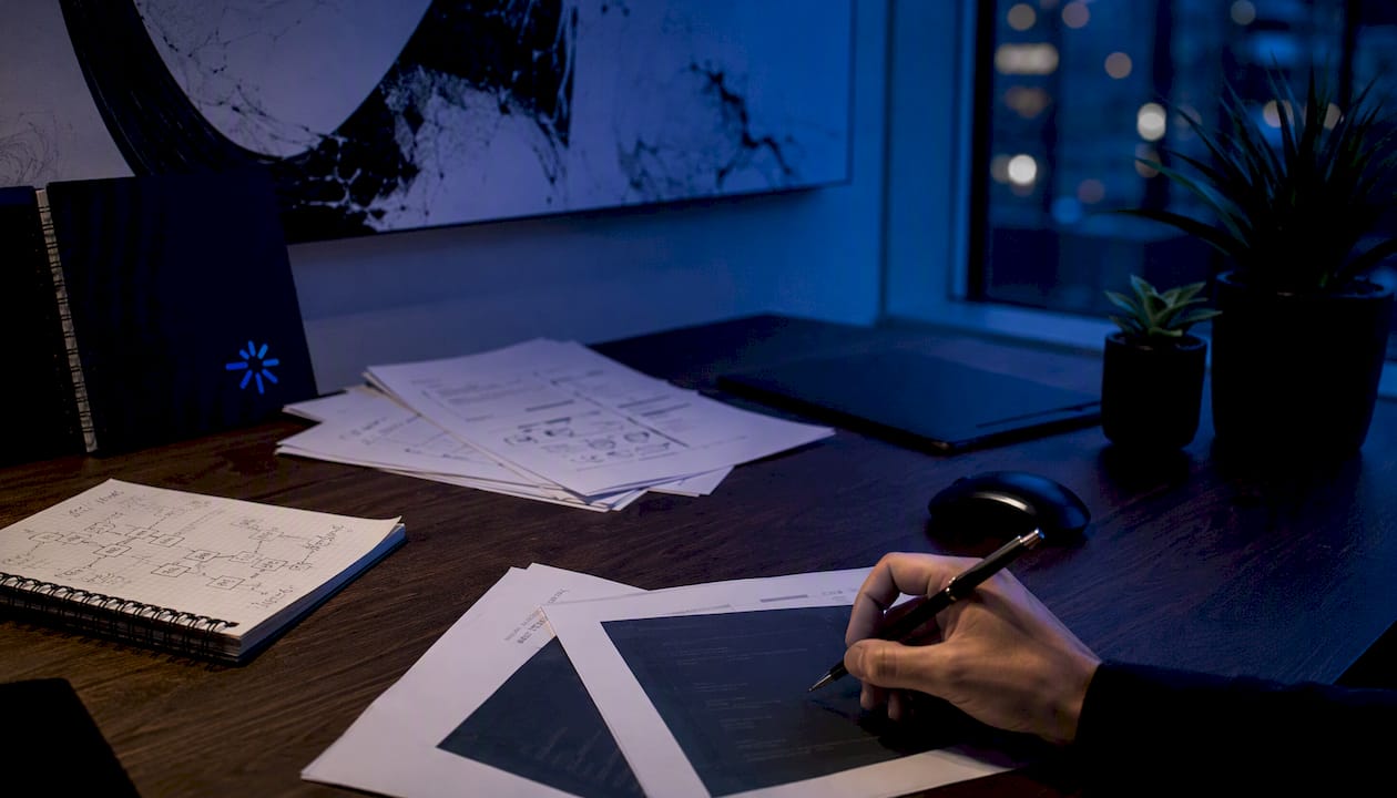 Close-up of hands and API code printouts on dark desk