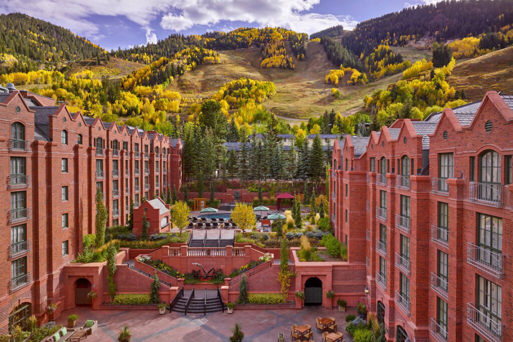 The St. Regis Aspen Resort wedding venue with red brick architecture against autumn mountains