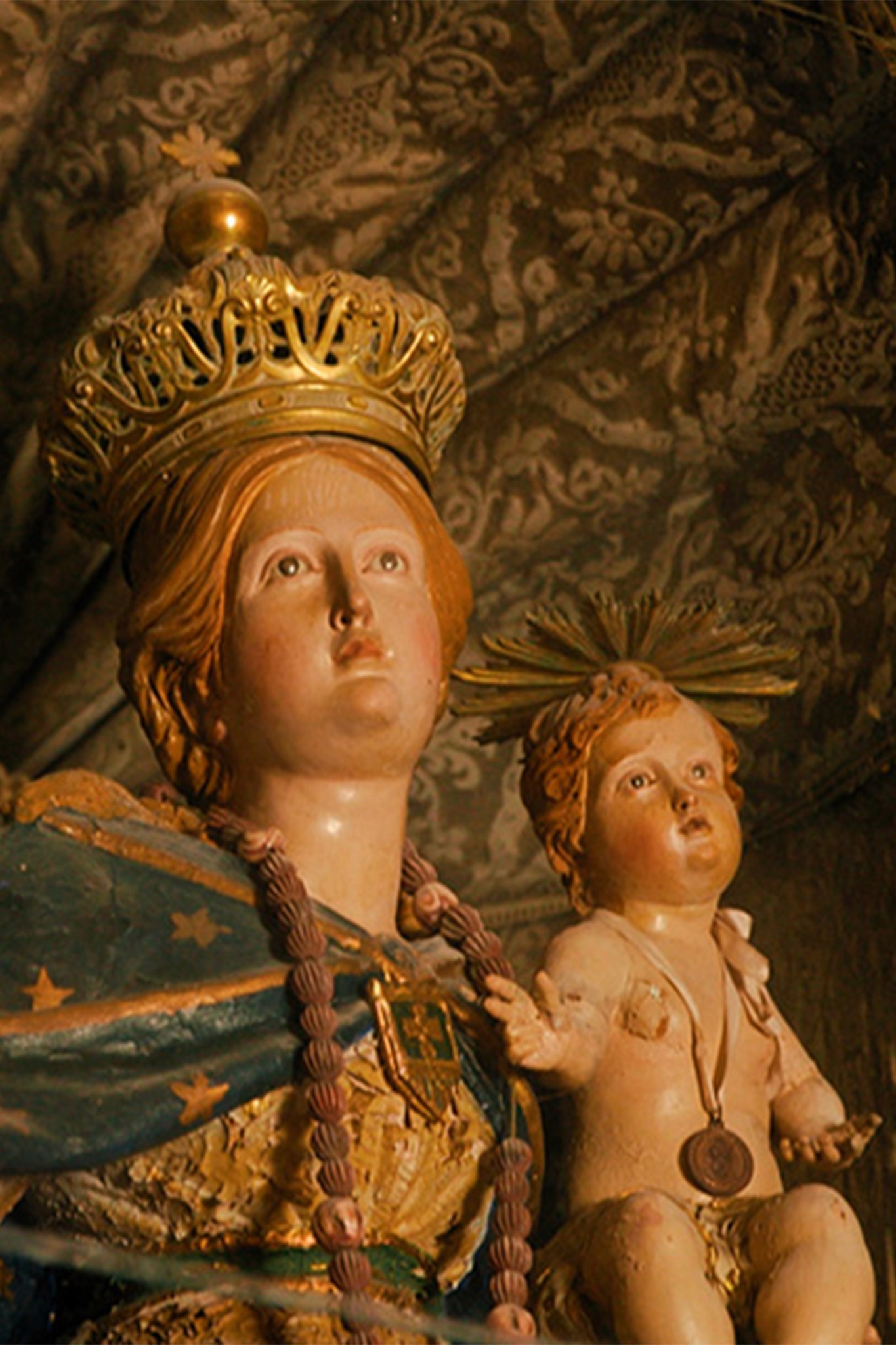 A bride in a lace wedding dress gently holds.