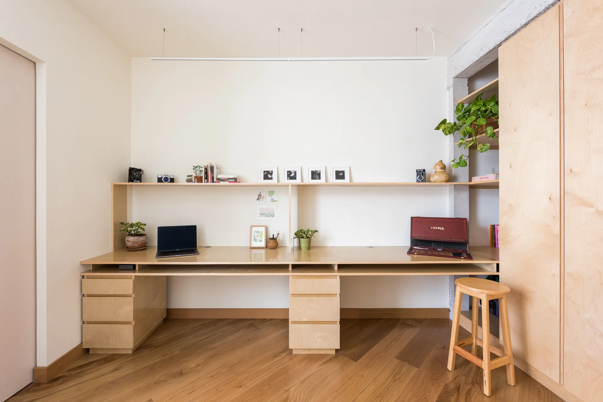 Oficina en casa con escritorio largo de madera y repisas de libros