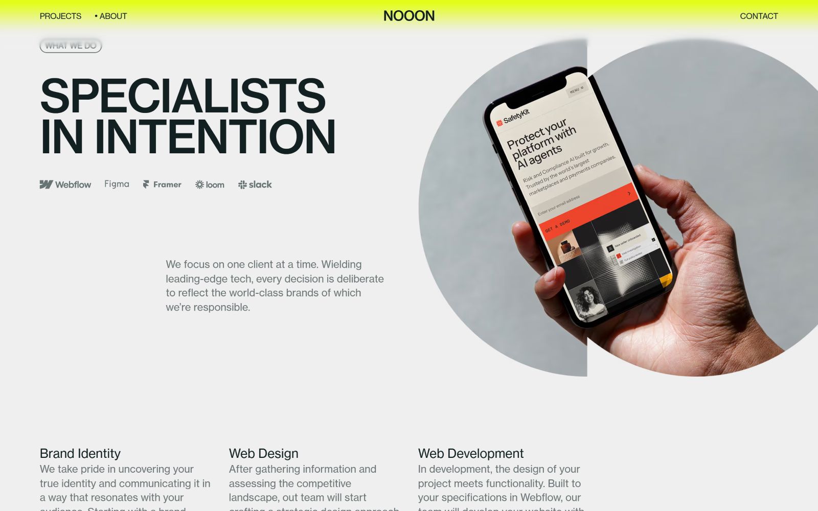 Specialists shown holding a smartphone displaying a website. Text: "SPECIALISTS IN INTENTION," branding elements, and project services listed.