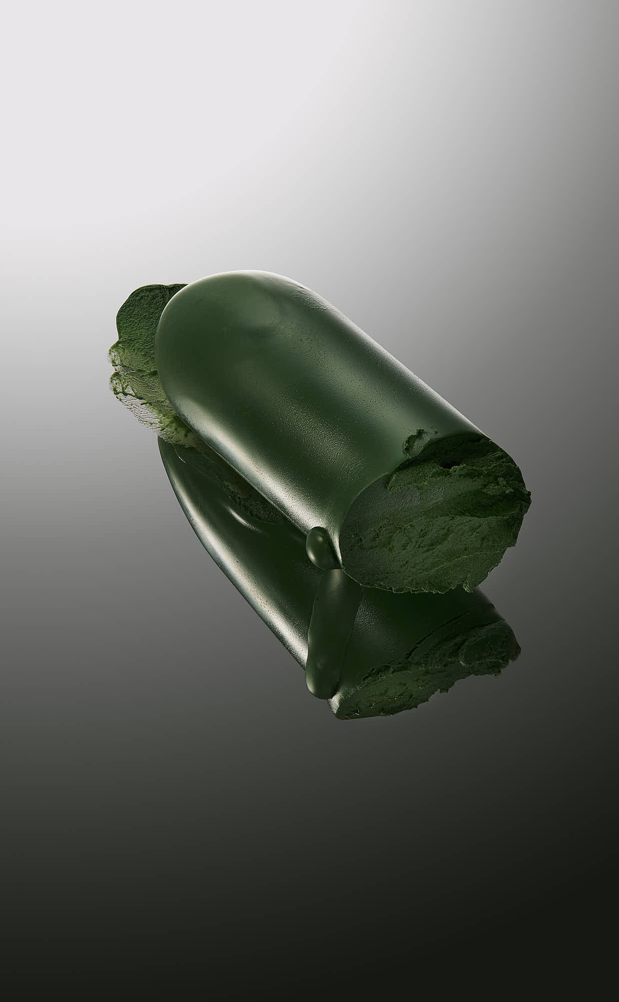 Green lipstick swatch on reflective surface.