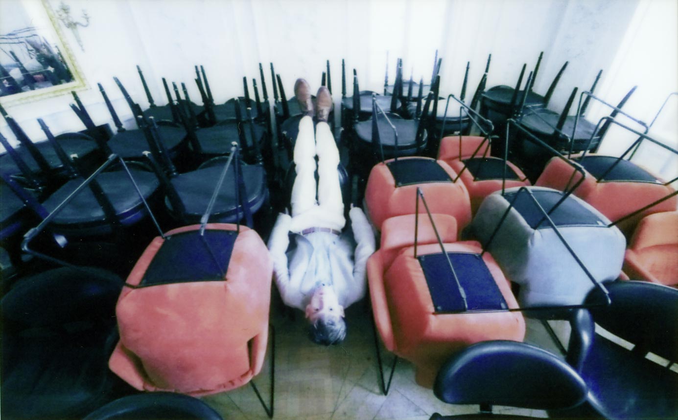 Dominik Türk, head of studios, sitting the wrong way on a chair in the middle of a chair storage area
