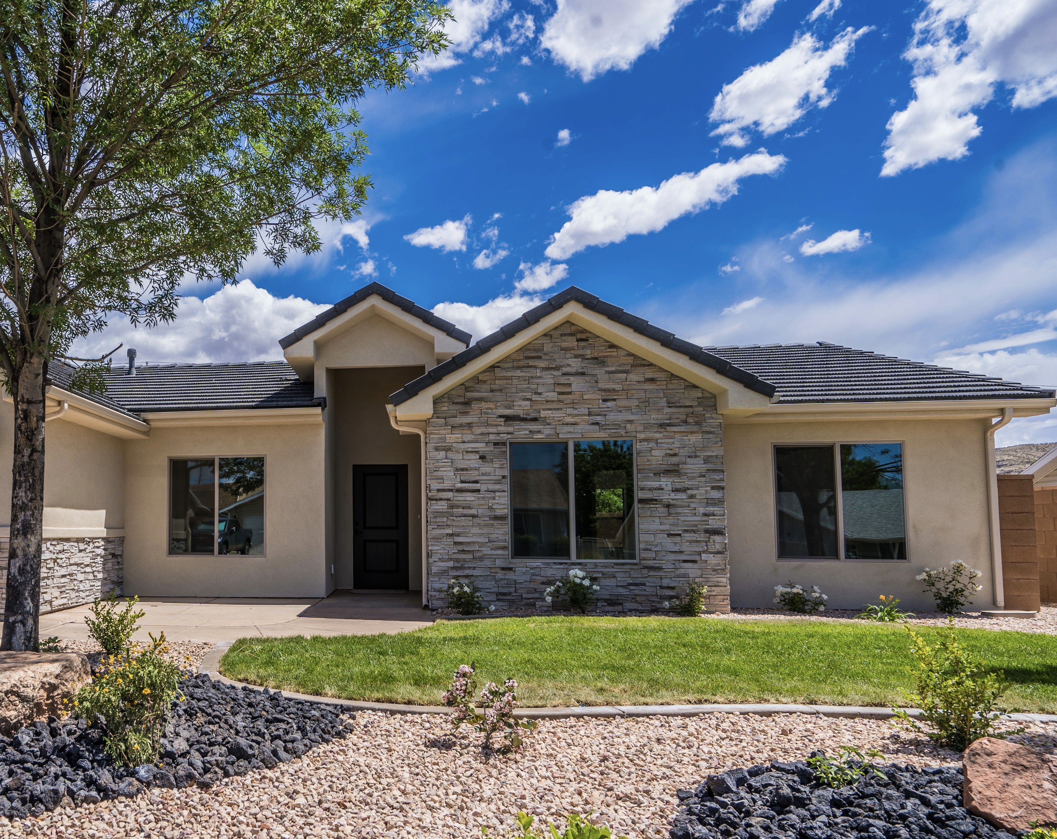 Updated home exterior in Southern Utah featuring grey, white, and black stone design elements.